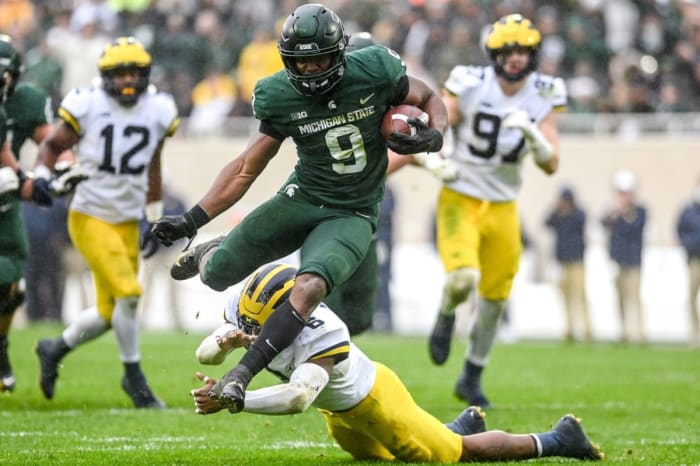 Michigan State's Kenneth Walker III avoids a tackle by Michigan's R.J. Moten during a touchdown run. Nick King/USA TODAY NETWORK / USA TODAY NETWORK